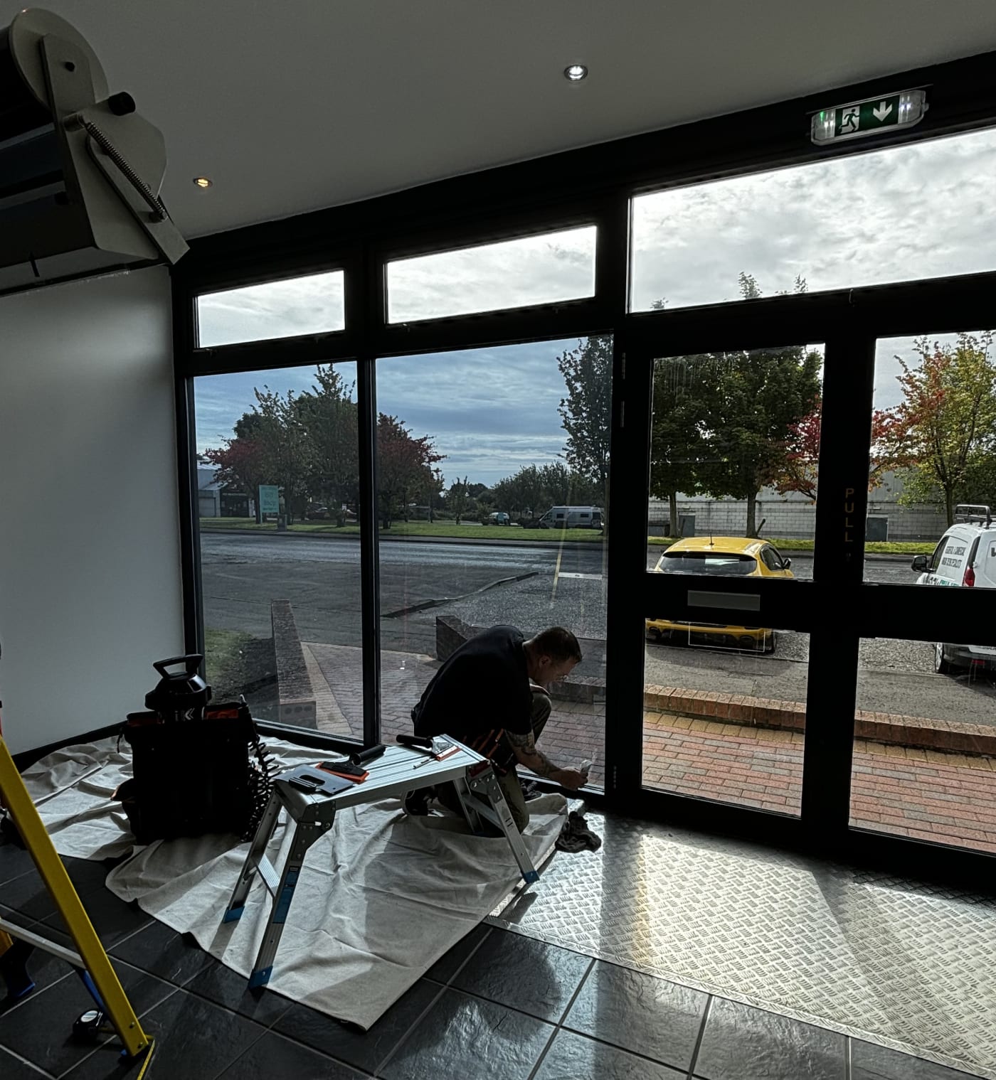 Commercial window film being installed on a shopfront entrance in Scotland